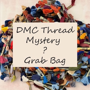 May include: A pile of colorful DMC embroidery floss skeins in various shades of blue, orange, red, and green. A cream-colored card displays the text "DMC Thread Mystery? Grab Bag" in black cursive font.