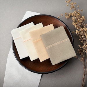 May include: A set of three ceramic mugs with a speckled, matte finish. The mugs are in shades of cream, light gray, and dark gray. Each mug has a simple, minimalist design and a rounded handle.