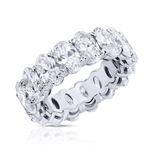 Peut inclure: Une bague éternelle en platine avec une rangée de diamants de forme ovale sertis pavé.