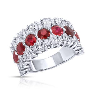 May include: A white gold ring with a row of red rubies and a row of pear-shaped diamonds.