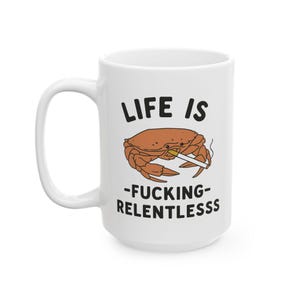 May include: White ceramic mug with the text "LIFE IS -FUCKING- RELENTLESSSS" in black. A cartoon crab with a cigarette is in the center. The mug has a large handle.