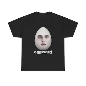 Peut inclure: T-shirt noir avec un motif d'œuf blanc représentant un visage humain et le texte "eggward" imprimé en blanc.