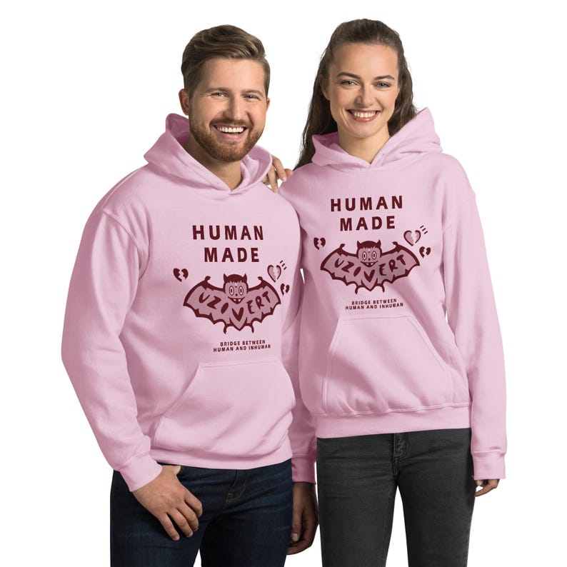 Pu&ograve; includere: Due felpe con cappuccio rosa con una grafica di pipistrello bordeaux e il testo "Human Made" e "Uzi Vert" sul davanti. Il testo sotto la grafica del pipistrello recita "Bridge Between Human and Infrahuman".