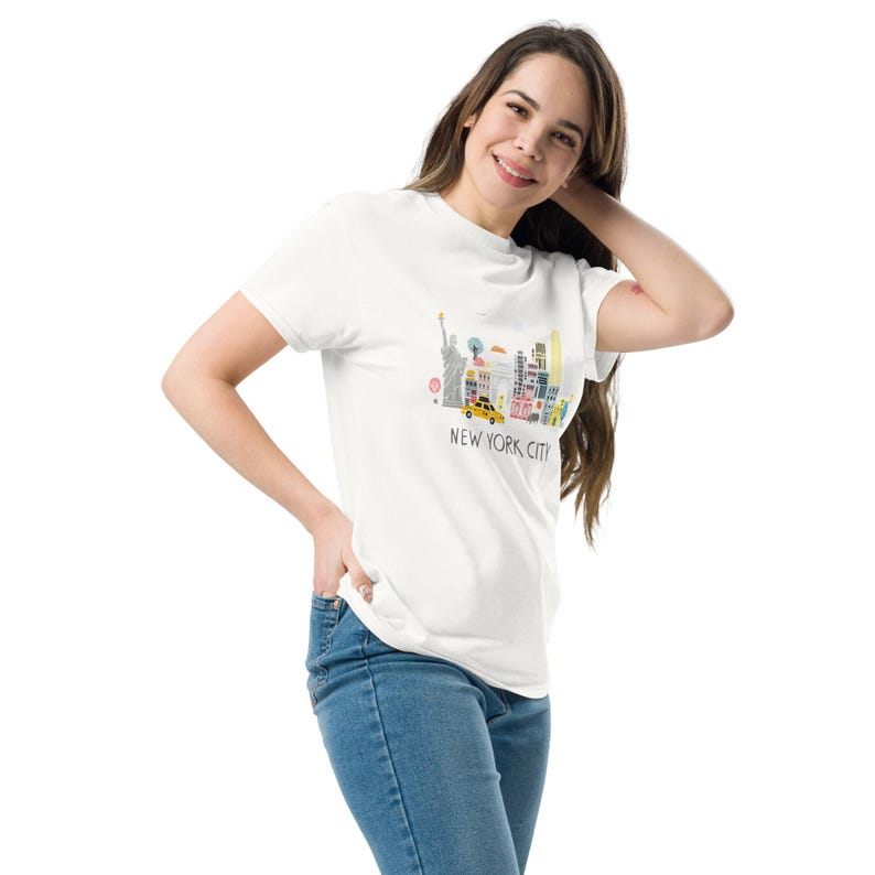 May include: White t-shirt with a colorful illustration of the New York City skyline, including the Statue of Liberty, skyscrapers, and a yellow taxi. The text "NEW YORK, CITY" is printed below the illustration.