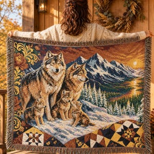 Peut inclure: Un plaid tissé représentant une scène détaillée d'une meute de loups dans un paysage de montagne enneigé au coucher du soleil. Le motif comprend deux loups adultes et deux louveteaux, entourés de sapins et de motifs géométriques sur les bords.