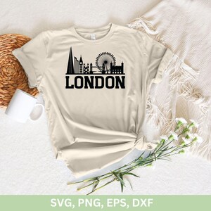 May include: A beige t-shirt with a black silhouette of the London skyline, including Big Ben, the London Eye, and Tower Bridge. The text "LONDON" is printed in black below the skyline.