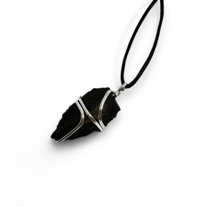 Peut inclure: Un pendentif en forme de pointe de flèche en pierre noire enveloppé de fil d'argent, suspendu à un collier en cordon noir.