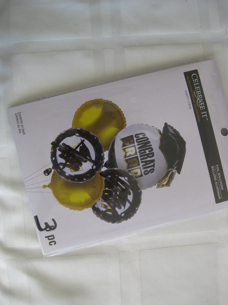 Graduation foil balloons and 2 gold foil balloons 18. 1 w Congrats Grads printed and a cap 26