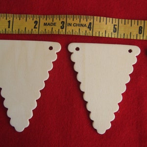 Wood scalloped triangles for banners, unfinished, 4 mm holes on top to string banner together. 3.5&quot; x 3.5&quot; x 2.75&quot; , lot of 12 triangles.
