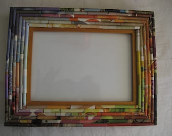 May include: A picture frame made from rolled up magazine pages. The frame is made of multiple layers of different colored magazine pages, creating a colorful and textured effect.