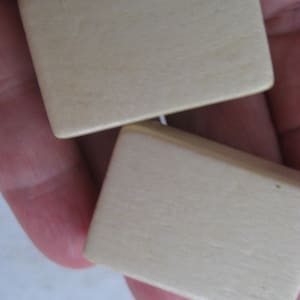 May include: Two small, rectangular, wooden boxes with a smooth, light beige finish.