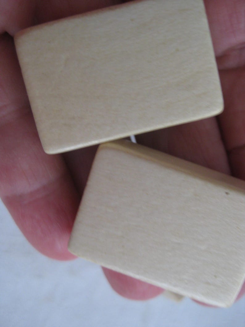 May include: Two small, rectangular, wooden boxes with a smooth, light beige finish.