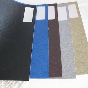 May include: A selection of seven fabric swatches in various colors and textures, including black, blue, brown, gray, beige, and white.