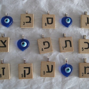 May include: A collection of 15 pendants, each featuring a blue evil eye charm or a Hebrew letter on a wooden tile. The tiles are numbered 1, 2, 3, 4, 5, and 8.