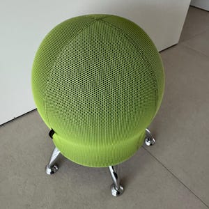 Op de afbeelding: Een limoengroene oefenbalstoel met een mesh hoes. De bal staat op een chromen basis met drie poten. De stoel is ontworpen voor actief zitten en ergonomische ondersteuning.