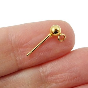 Peut inclure: Fermoir d'oreille en or avec une petite boule en haut et une boucle sur le côté.
