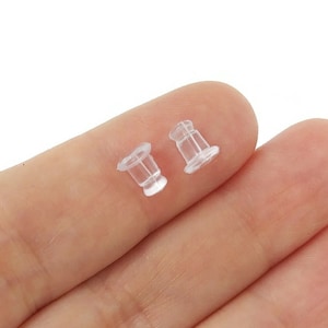 May include: Two clear plastic earring backs, designed to hold earrings in place.