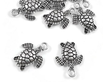 May include: A set of ten silver turtle charms with a detailed textured shell design. Each charm has a jump ring for attaching to jewelry or other crafts.