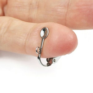 Peut inclure: Une pince d'oreille en métal argenté avec un sommet arrondi et un fermoir à ressort.