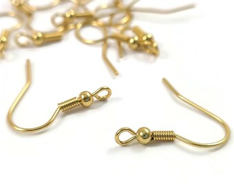 Peut inclure: Gros plan sur des crochets de boucles d'oreilles dorés avec une petite boule au sommet de chaque crochet. Les crochets sont en métal et ont une fermeture à ressort.