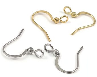 Peut inclure: Gros plan sur quatre crochets de boucles d'oreilles en or et argent. Deux sont de couleur or et deux sont de couleur argent. Chaque crochet a un design incurvé avec une petite boule et une boucle en haut.