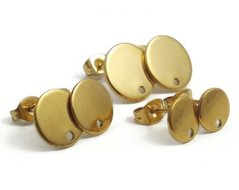 May include: Three pairs of gold-toned earring studs. Each stud features a round disc with a small hole in the center.