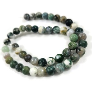 May include: A strand of green, white and brown agate beads. The beads are round and have a natural, polished finish.