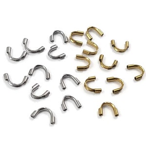 May include: A collection of gold and silver metal crimp beads. The beads are in the shape of a U and are used for jewellery making.