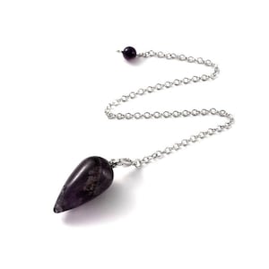 May include: A purple amethyst pendulum with a silver chain. The pendulum is teardrop shaped and has a silver loop at the top.