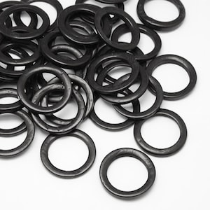 May include: A pile of black metal rings, likely used for attaching to fabric or other materials.