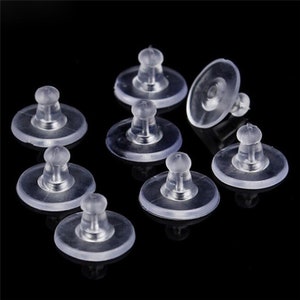 May include: Ten clear plastic earring backs with a small, round, raised centre. The backs are designed to hold earrings in place.