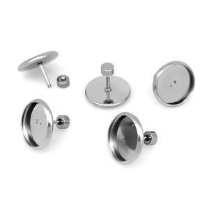 May include: A selection of silver earring components, including round bezel settings, posts, and a small nut. The components are arranged on a white background, highlighting their reflective surfaces and simple design. Suitable for jewellery making.