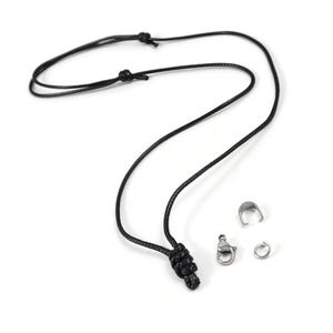 May include: A black cord necklace with a silver clasp and a silver jump ring.