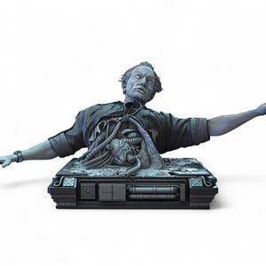 May include: A detailed bust sculpture of a man with exposed internal organs and wires, appearing to be a cyborg, with his arms outstretched. The bust is mounted on a black base with a textured surface.