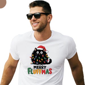 May include: White t-shirt with a black cat wearing a Santa hat and Christmas lights that says "Merry Fluffmas".
