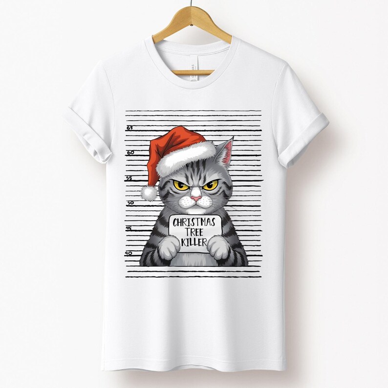 May include: A white t-shirt with a gray cat wearing a red Santa hat and holding a sign that says "Christmas Tree Killer". The cat is in front of a black and white striped background.