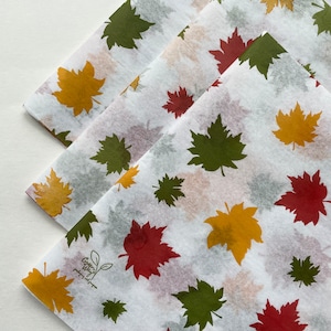 May include: White tissue paper with a fall leaf pattern in shades of green, yellow, and red. The paper has the text "Green With It" printed on it.