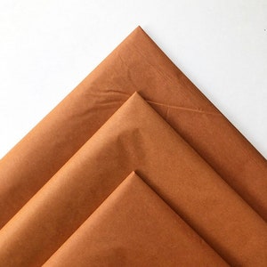 May include: Three sheets of brown tissue paper folded in a triangular shape.