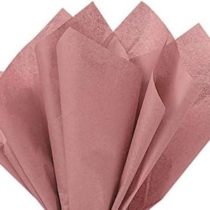 May include: A sheet of dusty rose tissue paper, folded in a fan shape.