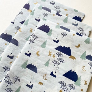 May include: Stack of four white tissue paper sheets with a repeating pattern of blue mountains, green trees, gold moons, and brown bears.