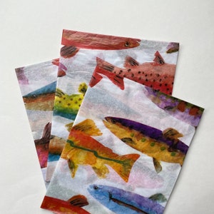 May include: Four sheets of colorful tissue paper with watercolor illustrations of fish. The fish are in various colors, including red, orange, yellow, green, blue, and purple. The tissue paper is perfect for wrapping gifts or adding a touch of whimsy to any project.