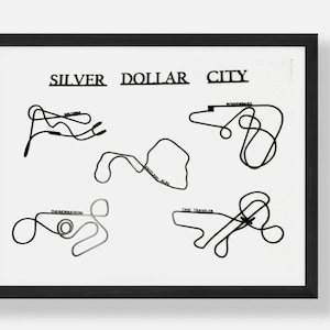 May include: Black framed print featuring the words "SILVER DOLLAR CITY" above stylized black line drawings of roller coaster tracks. The names of the rides, such as "Powder Keg" and "Time Traveler", are included.