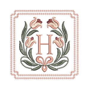 May include: Embroidered floral design featuring the letter "H" in a soft pink hue, surrounded by stylized flowers and leaves in muted green and pink tones. The design is framed by a delicate, scalloped border with a repeating floral pattern.