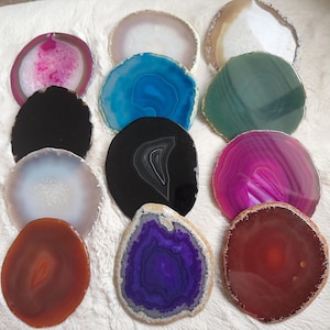 May include: Assortment of 10 agate coasters in various colours and patterns, including pink, blue, green, black, white, purple, and red. The coasters are made of natural agate and have a polished finish.