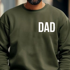 May include: A dark green sweatshirt with the word "DAD" printed in white on the front.