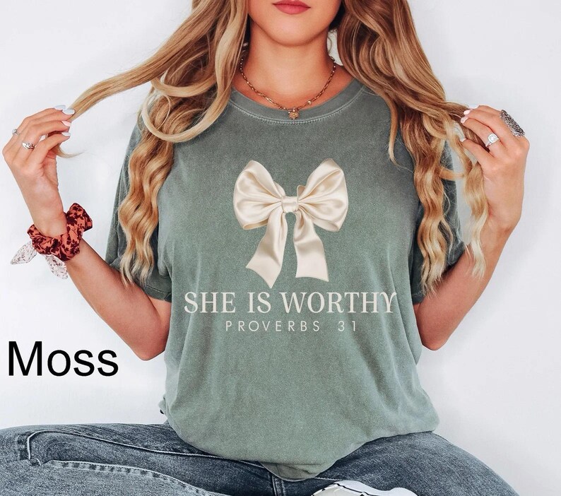 May include: A green t-shirt with a white bow and the text "She is Worthy Proverbs 31" printed on the front.