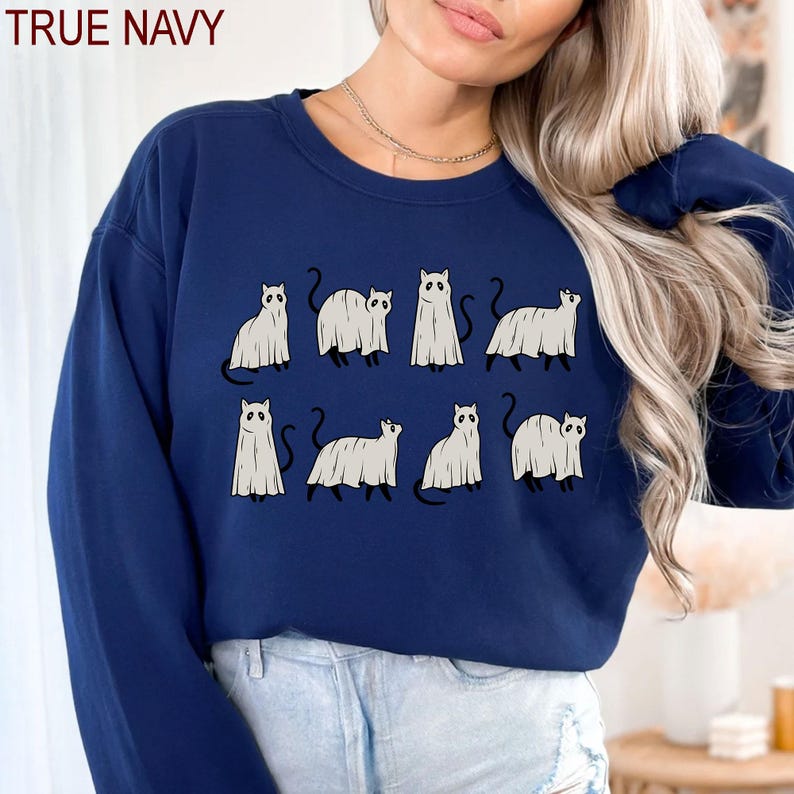 May include: A navy blue sweatshirt with a graphic of nine white ghost cats. The text "TRUE NAVY" is printed in white at the top of the image.