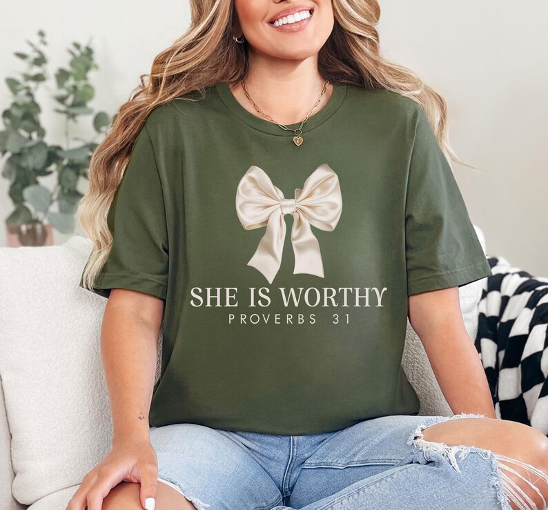 May include: A green t-shirt with a white bow and the text "She is Worthy Proverbs 31" printed on the front.