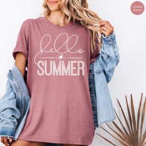 May include: A heather mauve t-shirt with the text "hello summer" in white lettering. The text includes a small sun graphic.