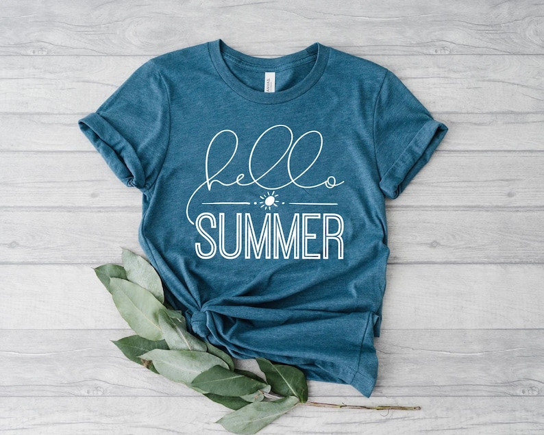 May include: A teal blue t-shirt with the text "hello summer" in white lettering. The text is in a cursive font with a sun and a line underneath.